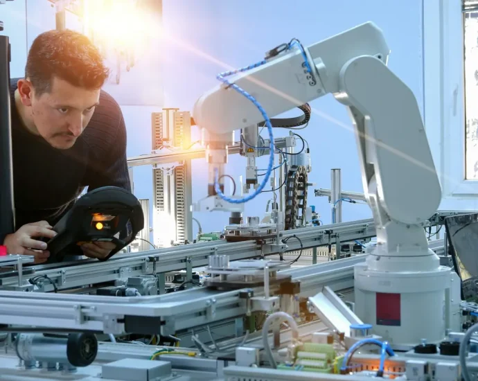 mężczyzna steruje robotem przemysłowym