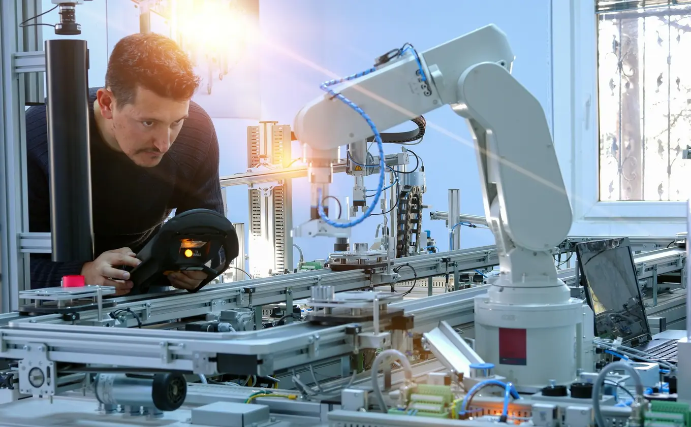 mężczyzna steruje robotem przemysłowym